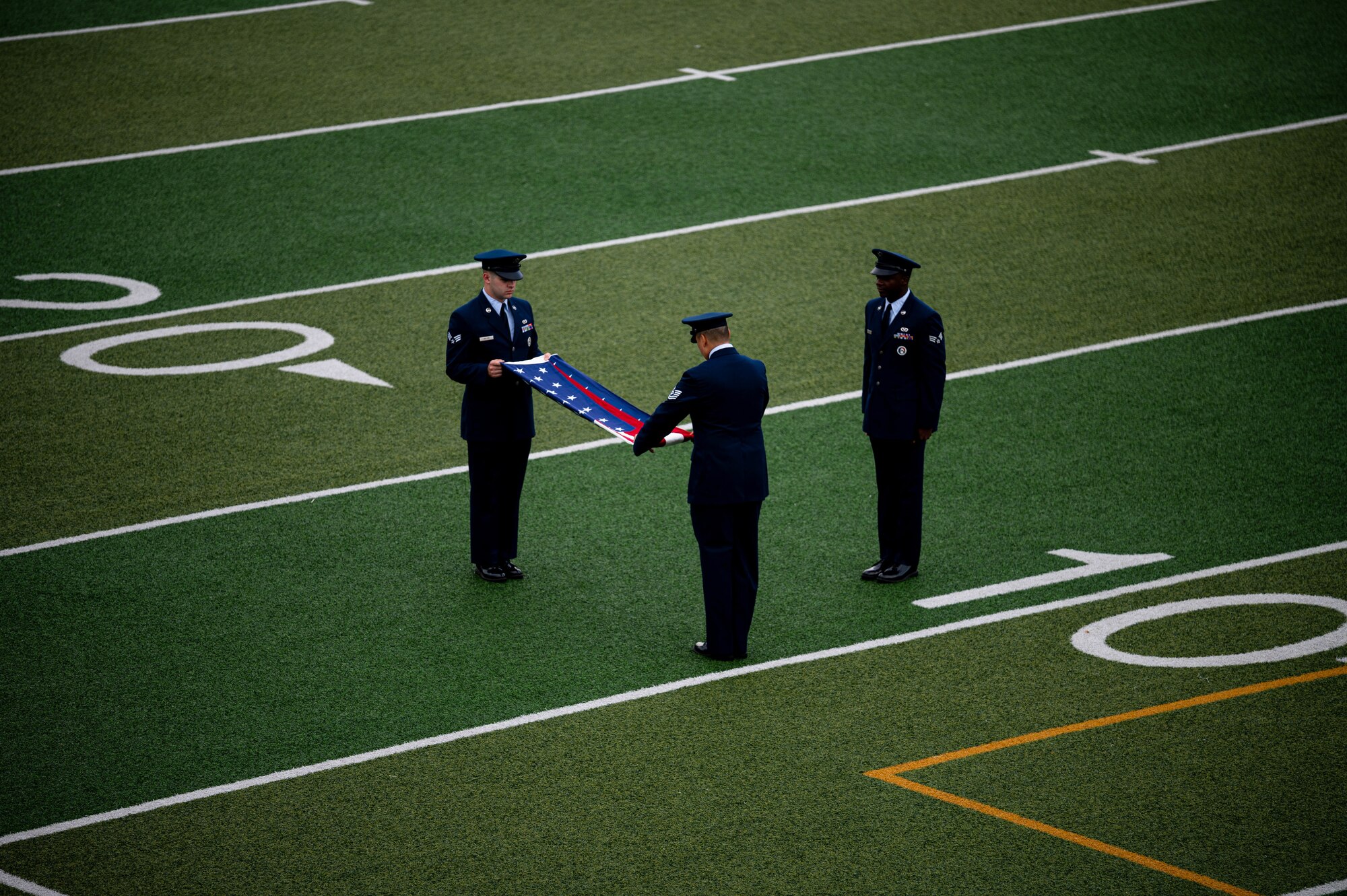 51st Fighter Wing honor guardsmen, fold a U.S. flag before a memorial ruck march