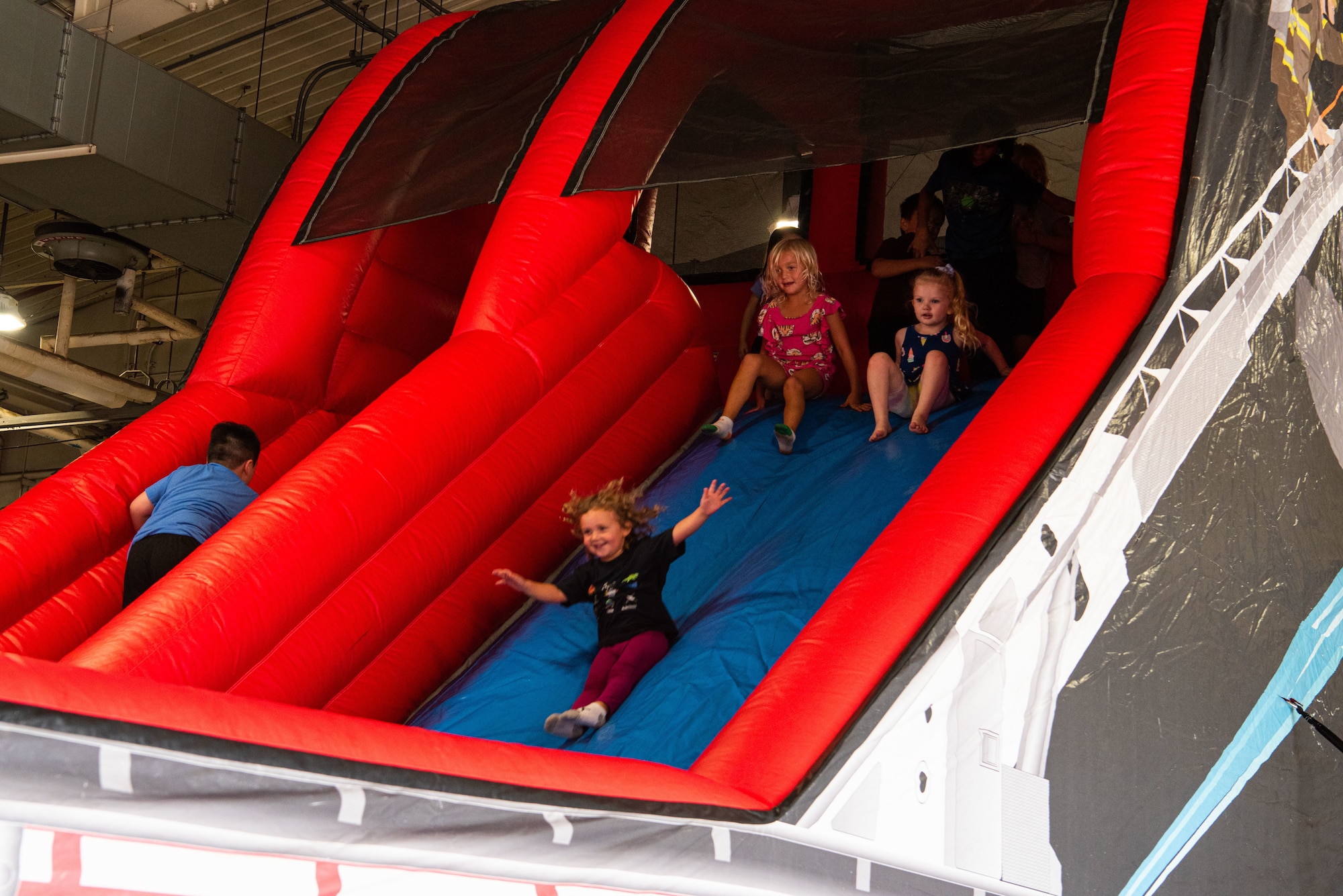 Children slide down a bounce-house during a Fire Prevention Week open house event at Osan Air Base, Republic of Korea, Oct. 9, 2021.