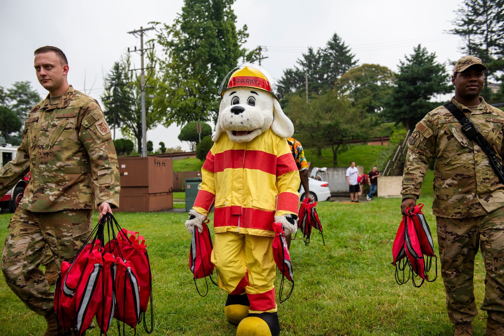 Sparky the Firedog and 51st Civil Engineer Squadron firemen bring presents for child attendees