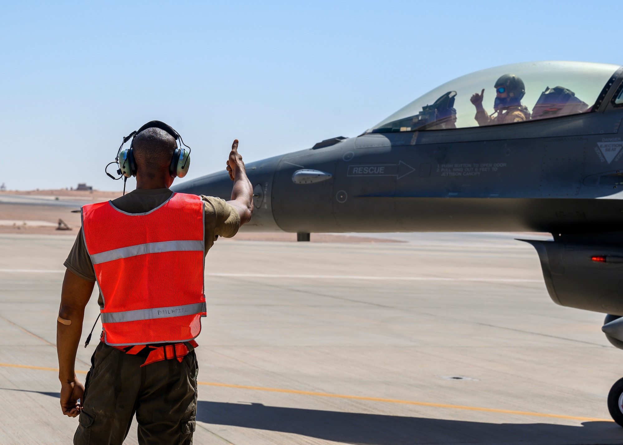U.S. Air Force Senior Airman Treveon Hampton, 332nd Air Expeditionary Wing F-15E crew chief, gives the F-16 pilot a thumbs up during hot pit training, Prince Sultan Air Base, Kingdom of Saudi Arabia, May 3, 2021. Maintenance crews assigned to the 332nd and 378th AEWs conducted a hot pit refueling training exchange over the course of several weeks, increasing their agile combat employment capabilities by ensuring both F-16 Fighting Falcons and F-15E Strike Eagles can be refueled by each wing. (U.S. Air Force Photo by Senior Airman Samuel Earick)