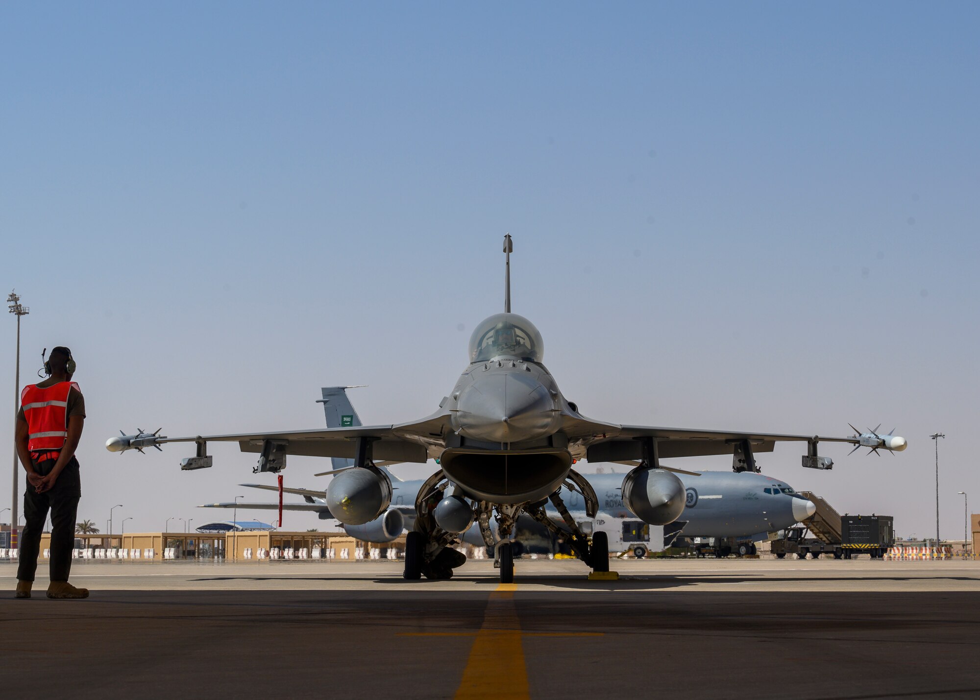 U.S. Air Force Senior Airmen Treveon Hampton and Nicholas Kunets, 332nd Air Expeditionary Wing F-15E crew chiefs, preform initial checks on a U.S. F-16 Fighting Falcon during hot pit training, Prince Sultan Air Base, Kingdom of Saudi Arabia, Sept. 25, 2021. Maintenance crews assigned to the 332nd and 378th AEWs conducted a hot pit refueling training exchange over the course of several weeks, increasing their agile combat employment capabilities by ensuring both F-16 Fighting Falcons and F-15E Strike Eagles can be refueled by each wing. (U.S. Air Force Photo by Senior Airman Samuel Earick)
