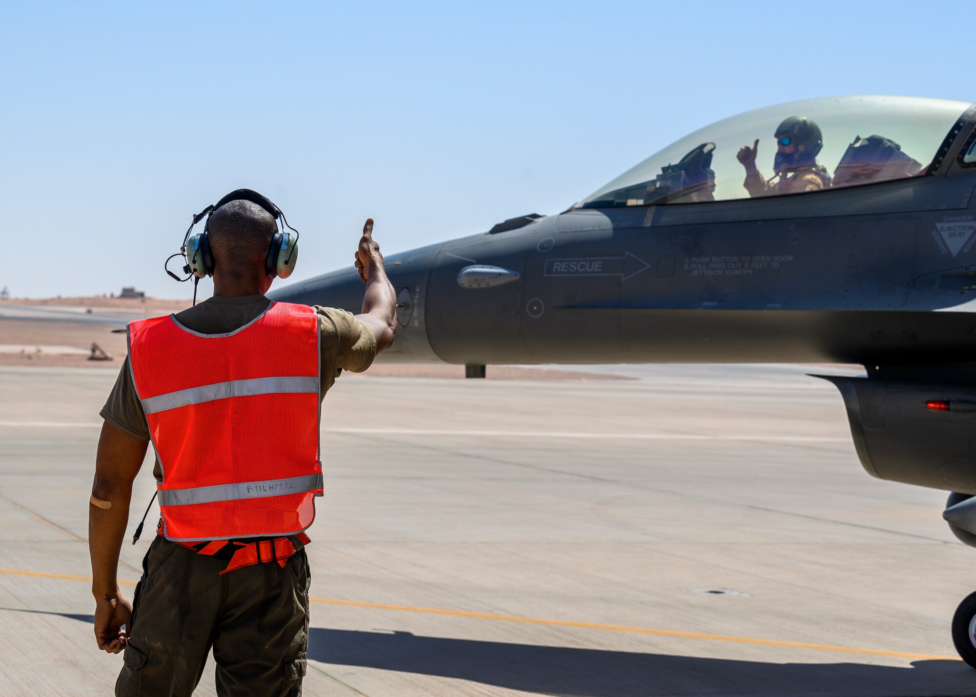 U.S. Air Force Senior Airman Treveon Hampton, 332nd Air Expeditionary Wing F-15E crew chief, gives the F-16 pilot a thumbs up during hot pit training, Prince Sultan Air Base, Kingdom of Saudi Arabia, May 3, 2021. Maintenance crews assigned to the 332nd and 378th AEWs conducted a hot pit refueling training exchange over the course of several weeks, increasing their agile combat employment capabilities by ensuring both F-16 Fighting Falcons and F-15E Strike Eagles can be refueled by each wing. (U.S. Air Force Photo by Senior Airman Samuel Earick)