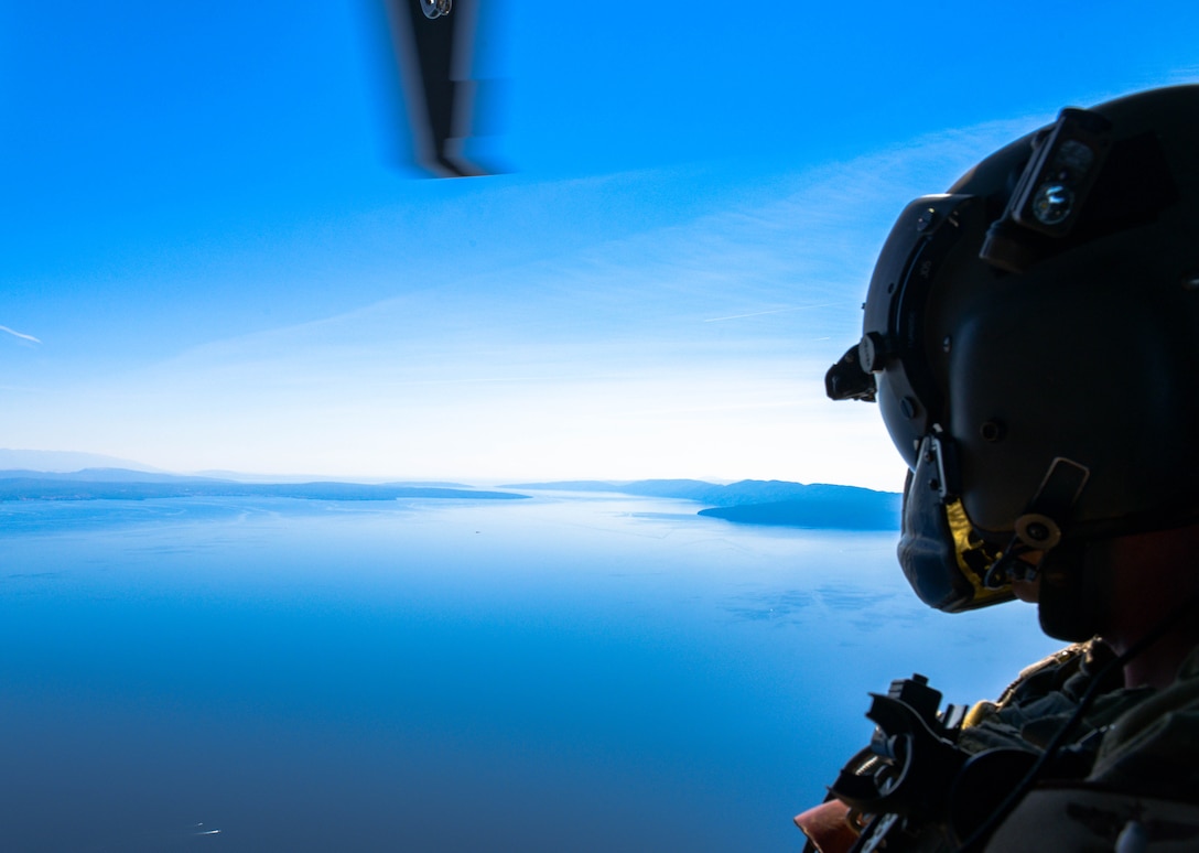 U.S. Air Force Master Sgt. Steven Prather, 56th Rescue Squadron operations superintendent, peers out the door of an HH-60G Pave Hawk A6212’s during its final flight in Croatia, Sept. 23, 2021. For more than 30 years, A6212 has been assigned exclusively to the 56th RQS. In September 2021, the helicopter is the first aircraft to retire out of the 56th with the plan to become a static display. (U.S. Air Force photo by Senior Airman Brooke Moeder)