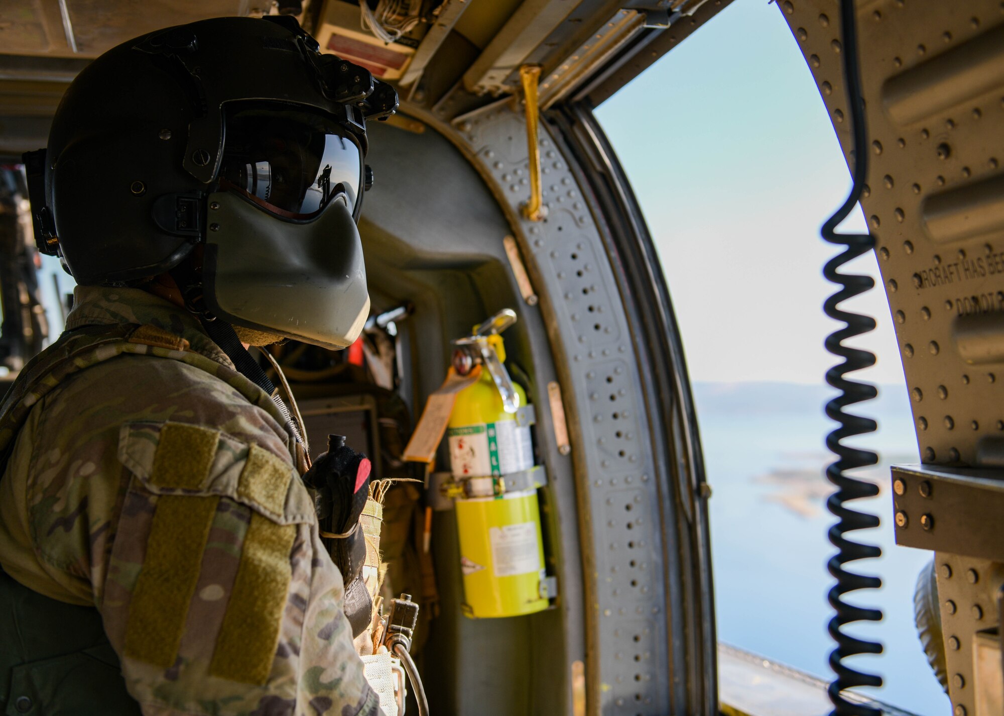 U.S. Air Force Staff Sgt. Kinga Hudson, 56th Rescue Squadron special missions aviator, looks out of an HH-60G Pave Hawk’s window during its final sortie, Sept. 23, 2021. There are five helicopters assigned to the 56th RQS with two retiring by the end of 2021. (U.S. Air Force photo by Senior Airman Brooke Moeder)