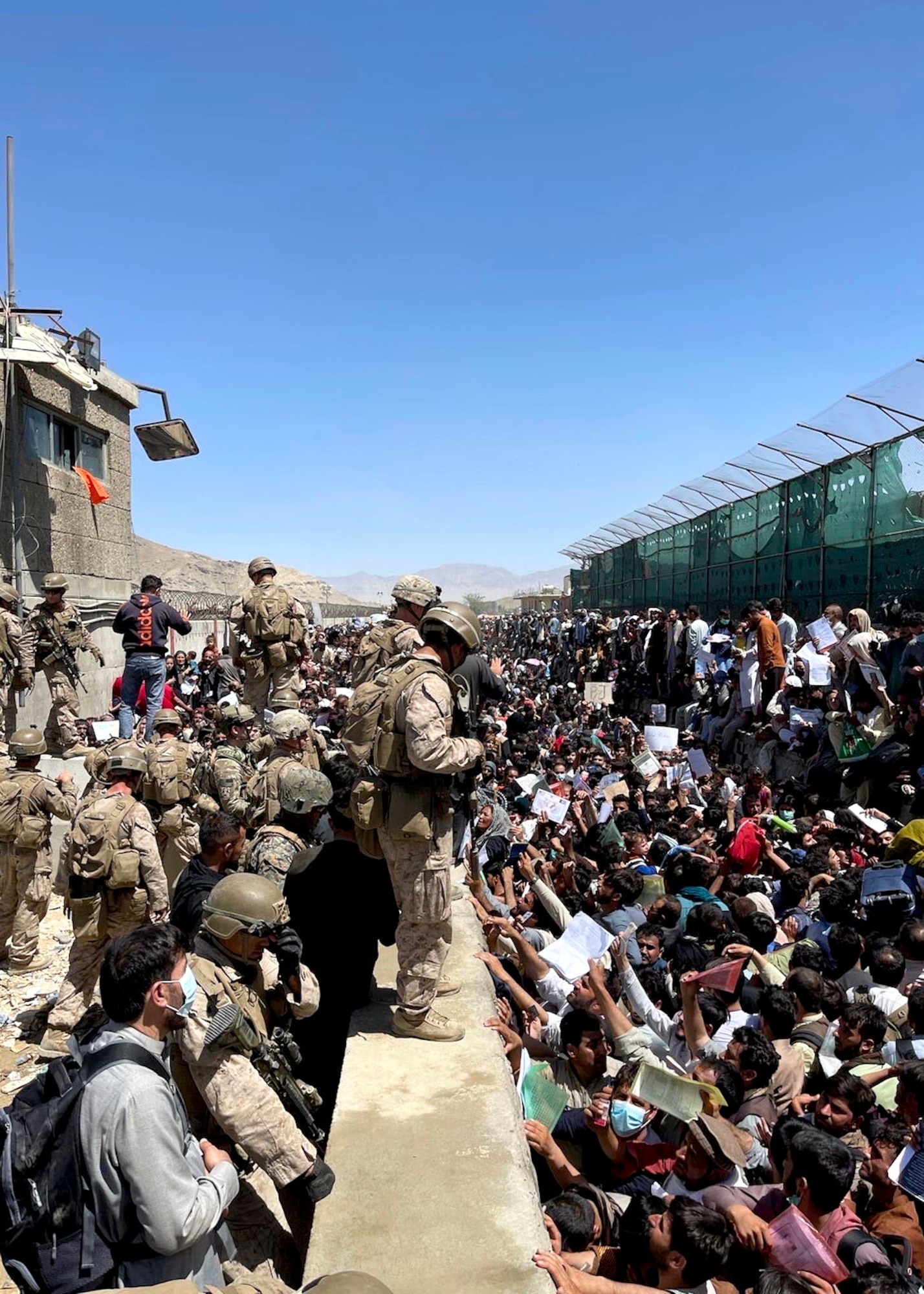 Service members stand on a wall