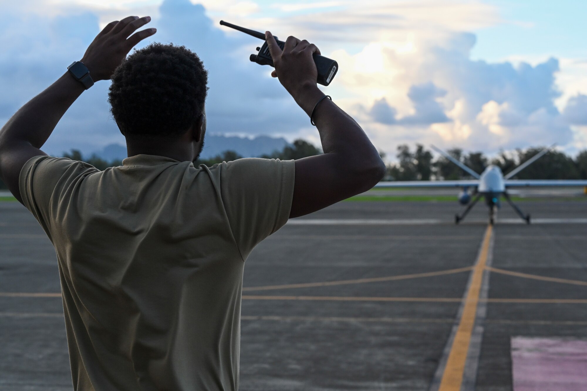 Staff Sgt. Christopher Herring, 556th Test and Evaluation Squadron operational suitability analyst, marshals an MQ-9 Reaper on the taxiway Sept. 13, 2021, on Marine Corps Base Hawaii. Exercise Agile Combat Employment Reaper is an opportunity to conduct training with joint partners in a maritime environment and in different airspaces. (U.S. Air Force photo by Airman 1st Class Adrian Salazar)