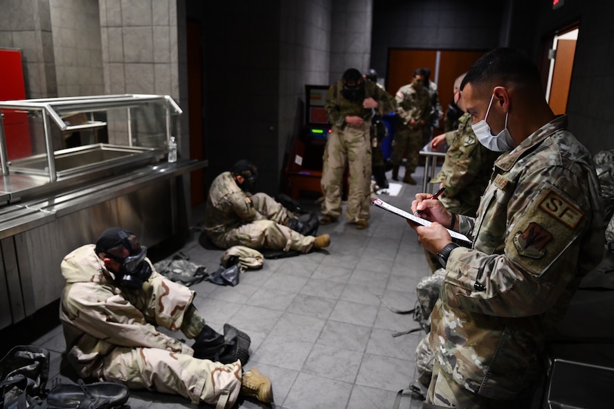 Senior Airman Ivan Villavincencio, 104th Security Forces Squadron defender, tests Soldiers and Airman on their chemical, biological, radiological, and nuclear protective posture proficiency during the German Armed Forces Proficiency Badge event Sept. 9, 2021, at Hanscom Air Force Base, Massachusetts. Participants in the event were tested over a three-day period on swimming, a ruck march, marksmanship, a fitness assessment, and more. (U.S. Air National Guard photo by Randy Burlingame)