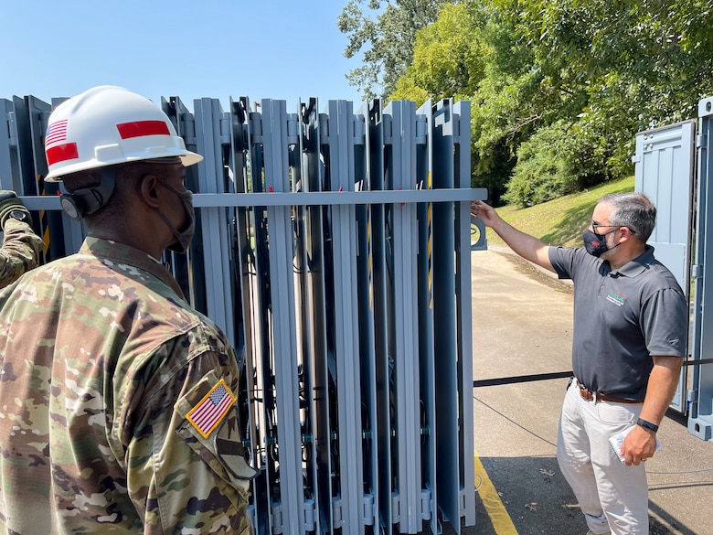 Omar Esquilin-Mangual, a structural engineer in the U.S. Army Engineer Research and Development Center-Geotechnical and Structures Laboratory’s Survivability Engineering Branch, discusses how the Rapid Armor Protection for Instant Deployment system is deployed once out of its container. (U.S. Army Corps of Engineers photo)