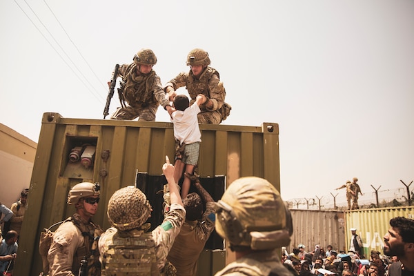 U.S. Marines and United Kingdom and Turkish coalition forces assist child during evacuation at Hamid Karzai International Airport, Kabul, Afghanistan, August 20, 2021 (U.S. Marine Corps/Victor Mancilla)