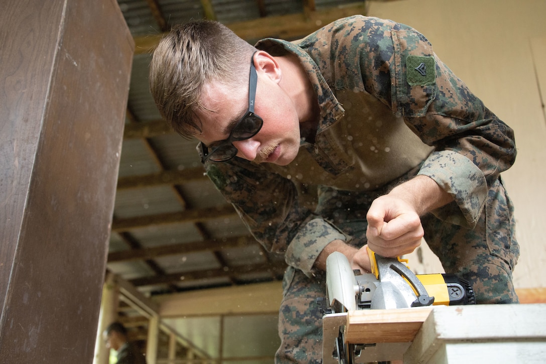 U.S. Marine Corps Cpl. Tyler Illingworth, a combat engineer with Task Force Koa Moana 21, I Marine Expeditionary Force, cuts plywood at Ngeremlengui Elementary School in Ngeremlengui, Republic of Palau, Oct. 2, 2021. Task Force Koa Moana 21 is a unifying mission that fosters enduring cooperation between the United States and the Republic of Palau.