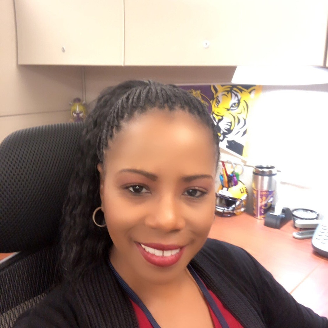 Smiling woman wears a red shirt and black sweater