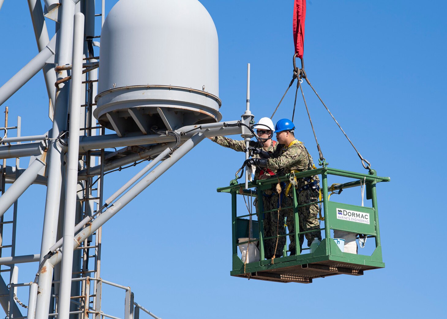 Information System Technician 2nd Class Nathan A. Milca, right, and Electronics Technician 2nd Class Drake W. Childers perform annual maintenance on the forward house antennae aboard the Expeditionary Sea Base USS Hershel "Woody" Williams (ESB 4) while moored in Cape Town, South Africa for a regularly scheduled maintenance period, Oct. 5, 2021.