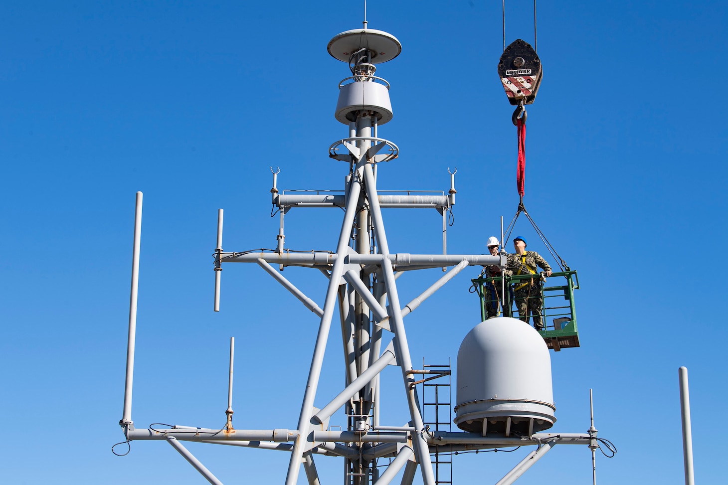 Information System Technician 2nd Class Nathan A. Milca, right, and Electronics Technician 2nd Class Drake W. Childers perform annual maintenance on the forward house antennae aboard the Expeditionary Sea Base USS Hershel "Woody" Williams (ESB 4) while moored in Cape Town, South Africa for a regularly scheduled maintenance period, Oct. 5, 2021.