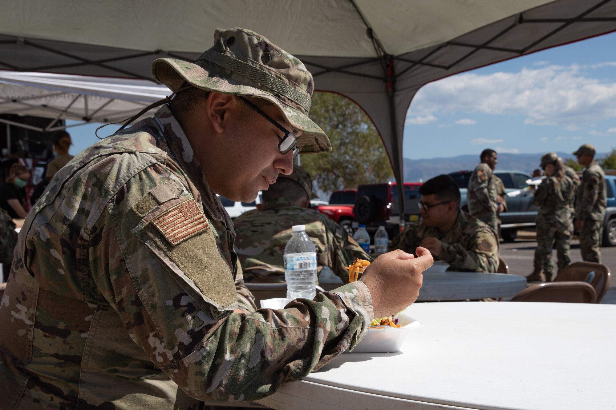 An Airman assigned to Task Force Holloman eats a free meal prepared by volunteers from Mountain View Church on Holloman Air Force Base, New Mexico, Oct. 5, 2021. The Department of Defense, through the U.S. Northern Command, and in support of the Department of State and Department of Homeland Security, is providing transportation, temporary housing, medical screening, and general support for at least 50,000 Afghan evacuees at suitable facilities, in permanent or temporary structures, as quickly as possible. This initiative provides Afghan evacuees essential support at secure locations outside Afghanistan. (U.S. Army photo by Spc. Nicholas Goodman)