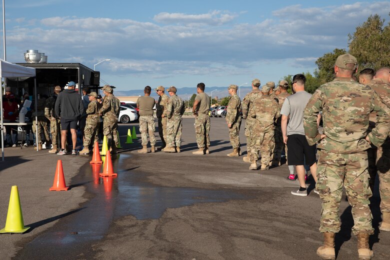 Service members assigned to Task Force Holloman wait in line to receive free food from Mountain View Church volunteers at Holloman Air Force Base, New Mexico, Oct. 5, 2021. The Department of Defense, through the U.S. Northern Command, and in support of the Department of State and Department of Homeland Security, is providing transportation, temporary housing, medical screening, and general support for at least 50,000 Afghan evacuees at suitable facilities, in permanent or temporary structures, as quickly as possible. This initiative provides Afghan evacuees essential support at secure locations outside Afghanistan. (U.S. Army photo by Spc. Nicholas Goodman)