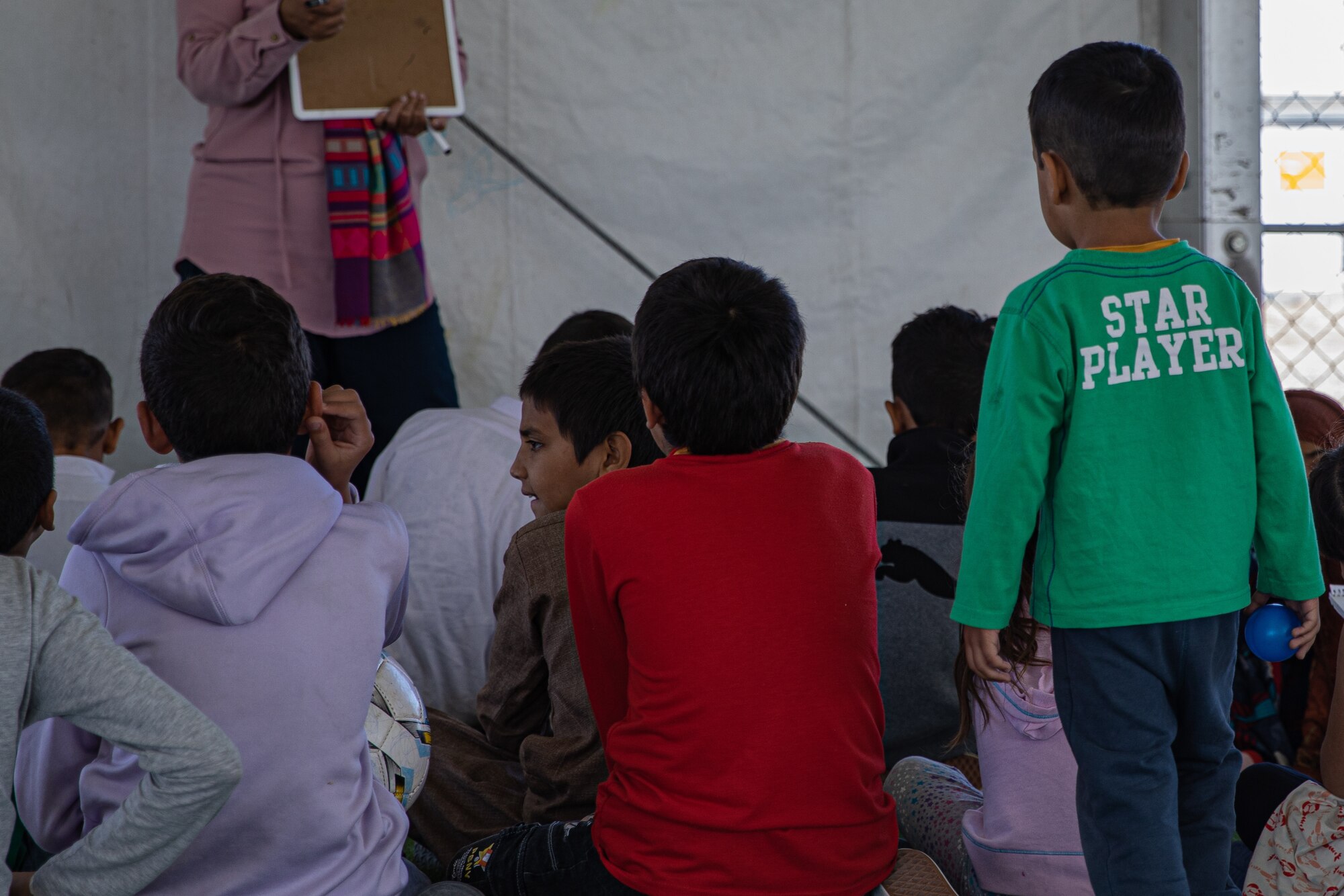 Afghan children attend English classes taught by Task Force Holloman members at Holloman Air Force Base, New Mexico, Oct. 5, 2021. The Department of Defense, through U.S. Northern Command, and in support of the Department of Homeland Security, is providing transportation, temporary housing, medical screening, and general support for at least 50,000 Afghan evacuees at suitable facilities, in permanent or temporary structures, as quickly as possible. This initiative provides Afghan personnel essential support at secure locations outside Afghanistan. (U.S. Army photo by Pfc. Anthony Sanchez)