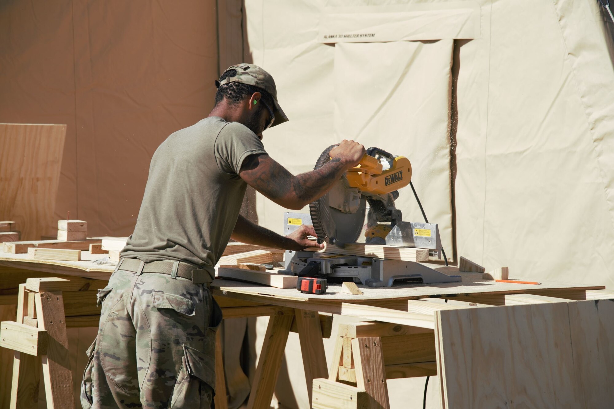 An Airman attached to TF Holloman creates support beams that will be used to create flooring in prayer tents at Holloman Air Force Base, New Mexico, Oct. 5, 2021. The Department of Defense, through U.S. Northern Command, and in support of the Department of State and Department of Homeland Security, is providing transportation, temporary housing, medical screening, and general support for at least 50,000 Afghan evacuees at suitable facilities, in permanent or temporary structures, as quickly as possible. This initiative provides Afghan evacuees essential support at secure locations outside Afghanistan. (U.S. Navy photo by Mass Communications Specialist 1st Class Sarah Rolin)
