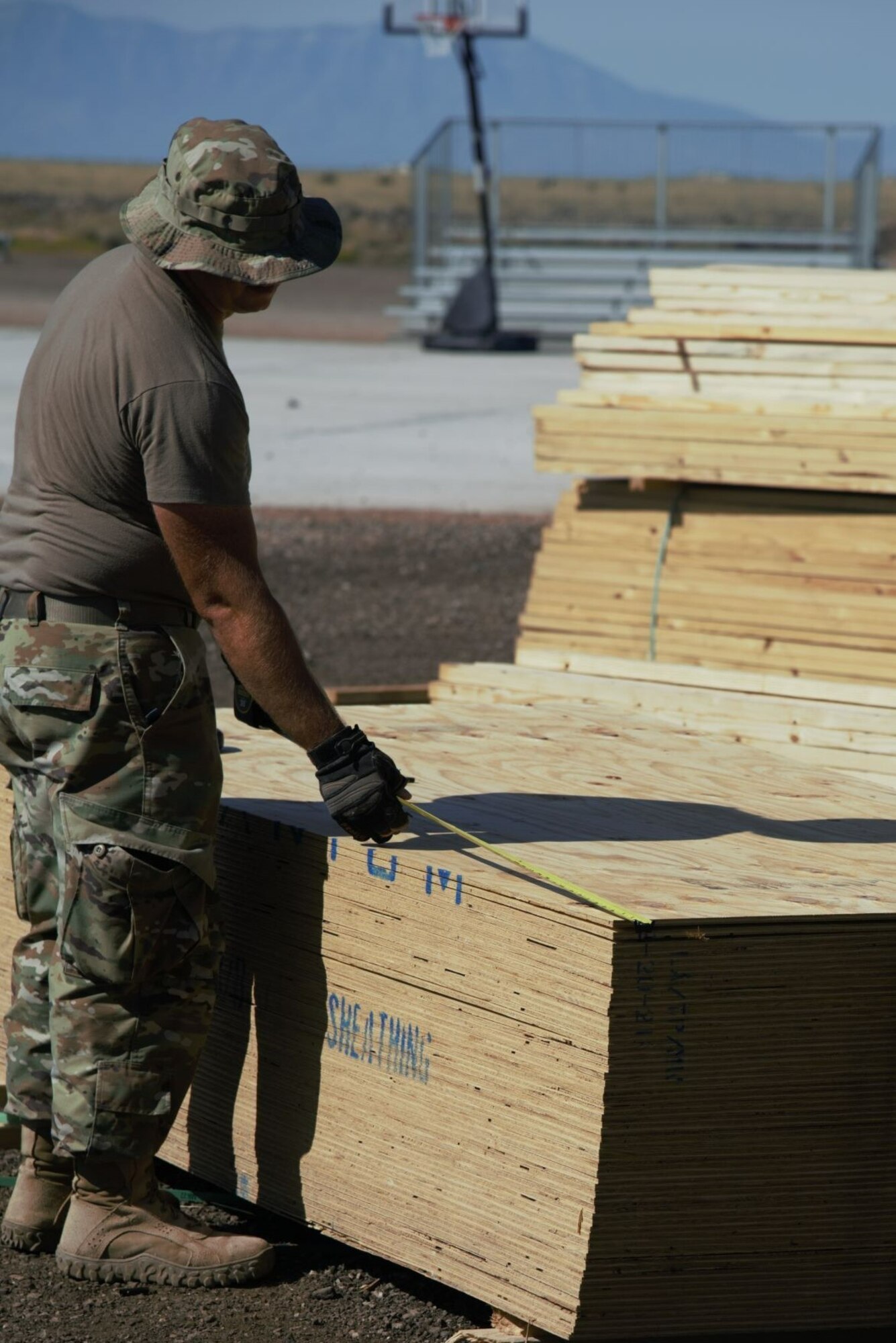 Wood planks are inspected and measured prior to being installed as flooring in the prayer tents located in Aman Omid Village at Holloman Air Force Base, New Mexico, Oct. 5, 2021. The Department of Defense, through U.S. Northern Command, and in support of the Department of State and Department of Homeland Security, is providing transportation, temporary housing, medical screening, and general support for at least 50,000 Afghan evacuees at suitable facilities, in permanent or temporary structures, as quickly as possible. This initiative provides Afghan evacuees essential support at secure locations outside Afghanistan. (U.S. Navy photo by Mass Communications Specialist 1st Class Sarah Rolin)