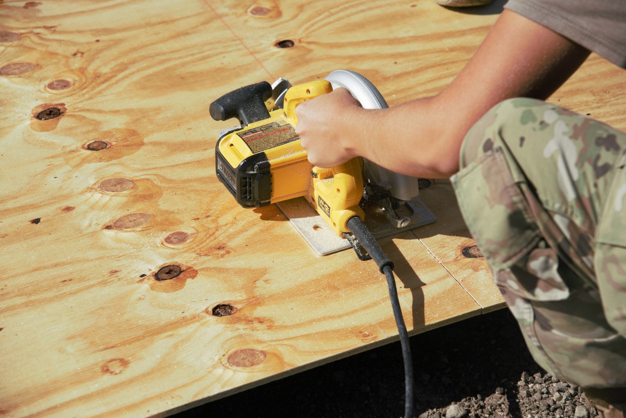 Using a hand saw, an Airman carefully cuts wood planks to the proper size prior to them being installed as flooring in prayer tents located in Aman Omid Village at Holloman Air Force Base, New Mexico, Oct. 5, 2021. The Department of Defense, through U.S. Northern Command, and in support of the Department of State and Department of Homeland Security, is providing transportation, temporary housing, medical screening, and general support for at least 50,000 Afghan evacuees at suitable facilities, in permanent or temporary structures, as quickly as possible. This initiative provides Afghan evacuees essential support at secure locations outside Afghanistan. (U.S. Navy photo by Mass Communications Specialist 1st Class Sarah Rolin)