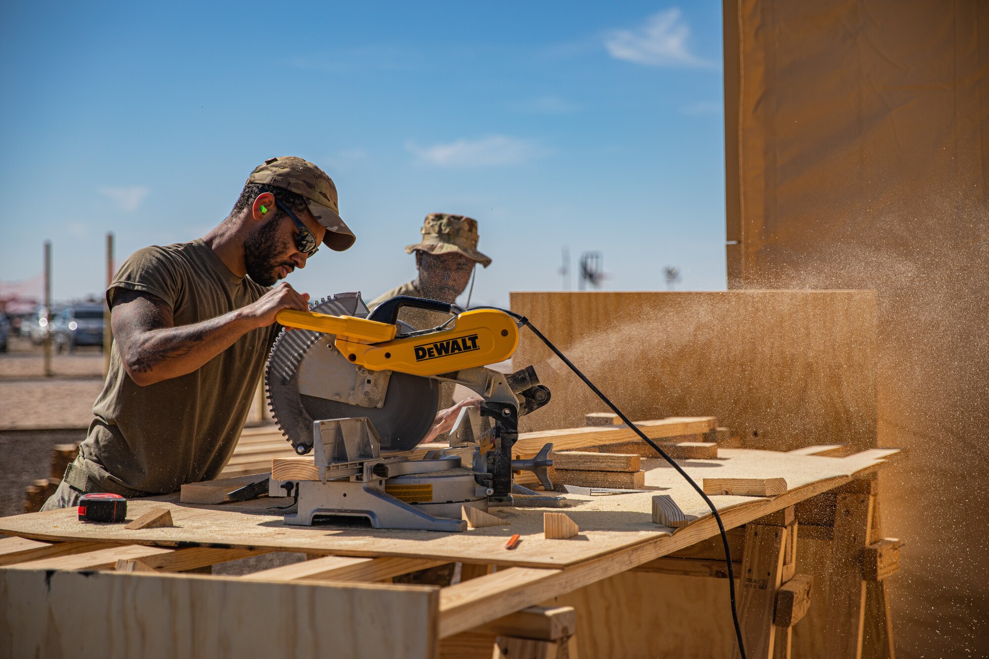 Airmen attached to Task Force Holloman cut wood as they construct flooring for prayer tents for Afghan evacuees at Aman Omid Village on Holloman Air Force Base, New Mexico, Oct. 5, 2021. The Department of Defense, through U.S. Northern Command, and in support of the Department of State and Department of Homeland Security, is providing transportation, temporary housing, medical screening, and general support for more than 50,000 Afghan evacuees at suitable facilities, in permanent or temporary structures, as quickly as possible. This initiative provides Afghan evacuees essential support at secure locations outside Afghanistan. (U.S. Army photo by Pfc. Anthony Sanchez)