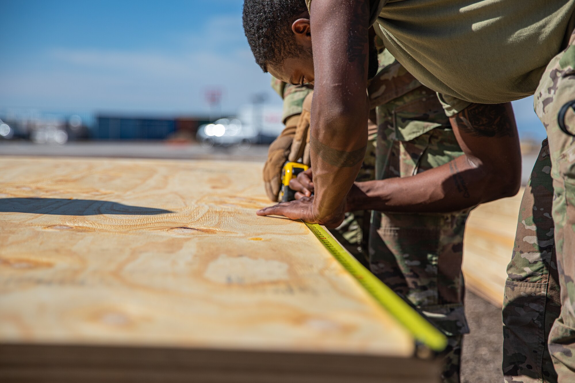 Airmen attached to Task Force Holloman cut wood as they construct flooring for prayer tents for Afghan evacuees at Aman Omid Village on Holloman Air Force Base, New Mexico, Oct. 5, 2021. The Department of Defense, through U.S. Northern Command, and in support of the Department of State and Department of Homeland Security, is providing transportation, temporary housing, medical screening, and general support for more than 50,000 Afghan evacuees at suitable facilities, in permanent or temporary structures, as quickly as possible. This initiative provides Afghan evacuees essential support at secure locations outside Afghanistan. (U.S. Army photo by Pfc. Anthony Sanchez)