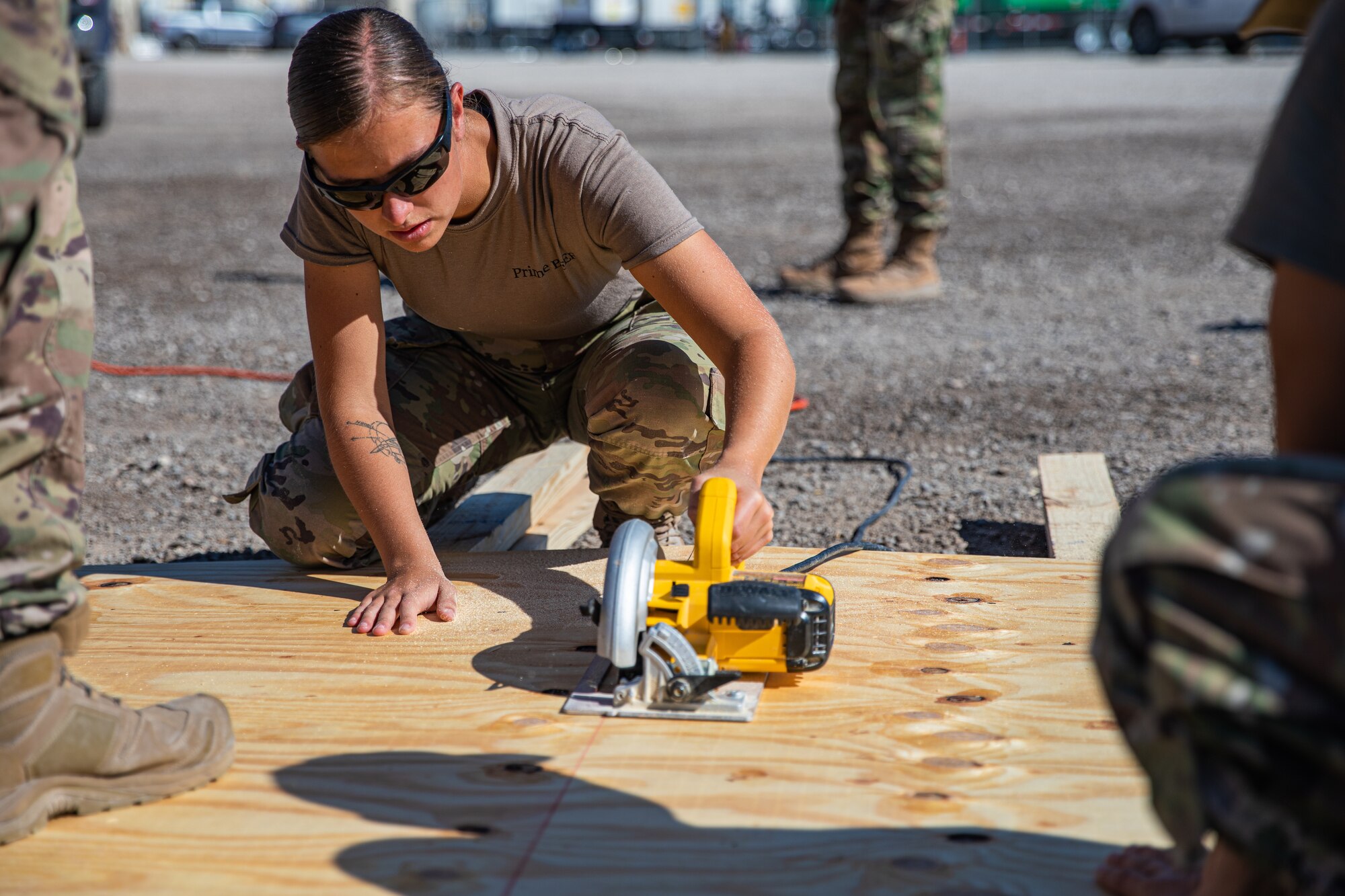 Airmen attached to Task Force Holloman cut wood as they construct flooring for prayer tents for Afghan evacuees at Aman Omid Village on Holloman Air Force Base, New Mexico, Oct. 5, 2021. The Department of Defense, through U.S. Northern Command, and in support of the Department of State and Department of Homeland Security, is providing transportation, temporary housing, medical screening, and general support for more than 50,000 Afghan evacuees at suitable facilities, in permanent or temporary structures, as quickly as possible. This initiative provides Afghan evacuees essential support at secure locations outside Afghanistan. (U.S. Army photo by Pfc. Anthony Sanchez)