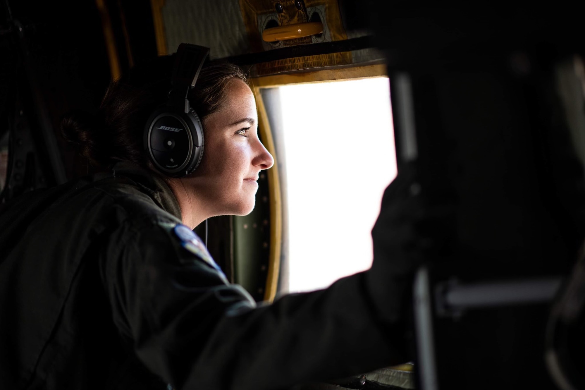 A photo of an Airman looking out of a window.