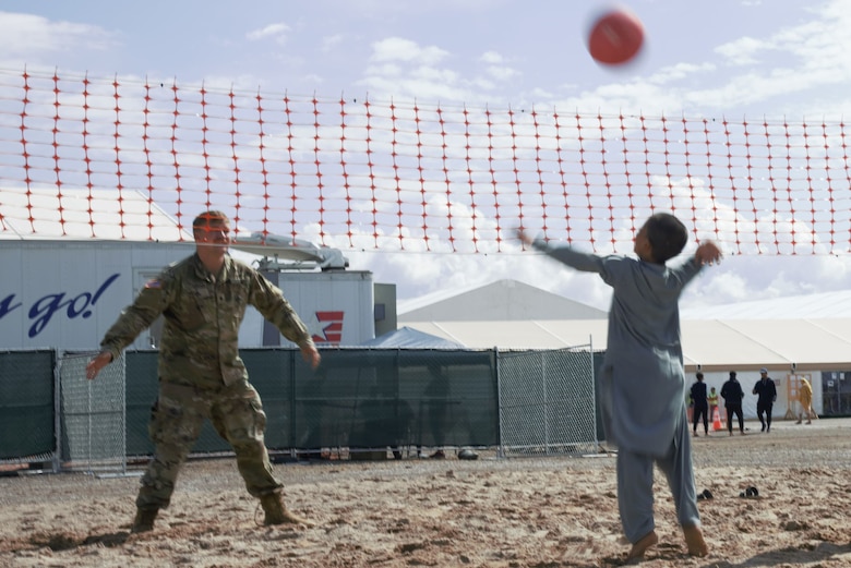 An intense volleyball game ensues between a Soldier assigned to Task Force-Holloman and an Afghan boy on Aman Omid Village on Holloman Air Force Base, New Mexico, Oct. 1, 2021. The Department of Defense, through U.S. Northern Command, and in support of the Department of State and Department of Homeland Security, is providing transportation, temporary housing, medical screening, and general support for at least 50,000 Afghan evacuees at suitable facilities, in permanent or temporary structures, as quickly as possible. This initiative provides Afghan evacuees essential support at secure locations outside Afghanistan. (U.S. Navy photo by Mass Communications Specialist 1st Class Sarah Rolin)
