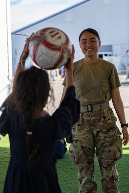 An Airman attached to Task Force-Holloman plays catch with an Afghan child at Aman Omid Village on Holloman Air Force Base, New Mexico, Oct. 7, 2021. The Department of Defense, through U.S. Northern Command, and in support of the Department of Homeland Security, is providing transportation, temporary housing, medical screening, and general support for at least 50,000 Afghan evacuees at suitable facilities, in permanent or temporary structures, as quickly as possible. This initiative provides Afghan personnel essential support at secure locations outside Afghanistan. (U.S. Army photo by Pfc. Anthony Sanchez)