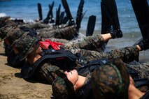 U.S. Marines with Co. C, 1st Battalion, 5th Marine Regiment, 1st Marine Division, conduct flutter kicks during a Scout Swimmer Course on Naval Amphibious Base Coronado, California, July 16, 2021. The Marines learned the skills necessary to plan and execute swimmer reconnaissance for a small boat raid company in preparation for deployment. (U.S. Marine Corps photo by Cpl. Jailine L. AliceaSantiago)