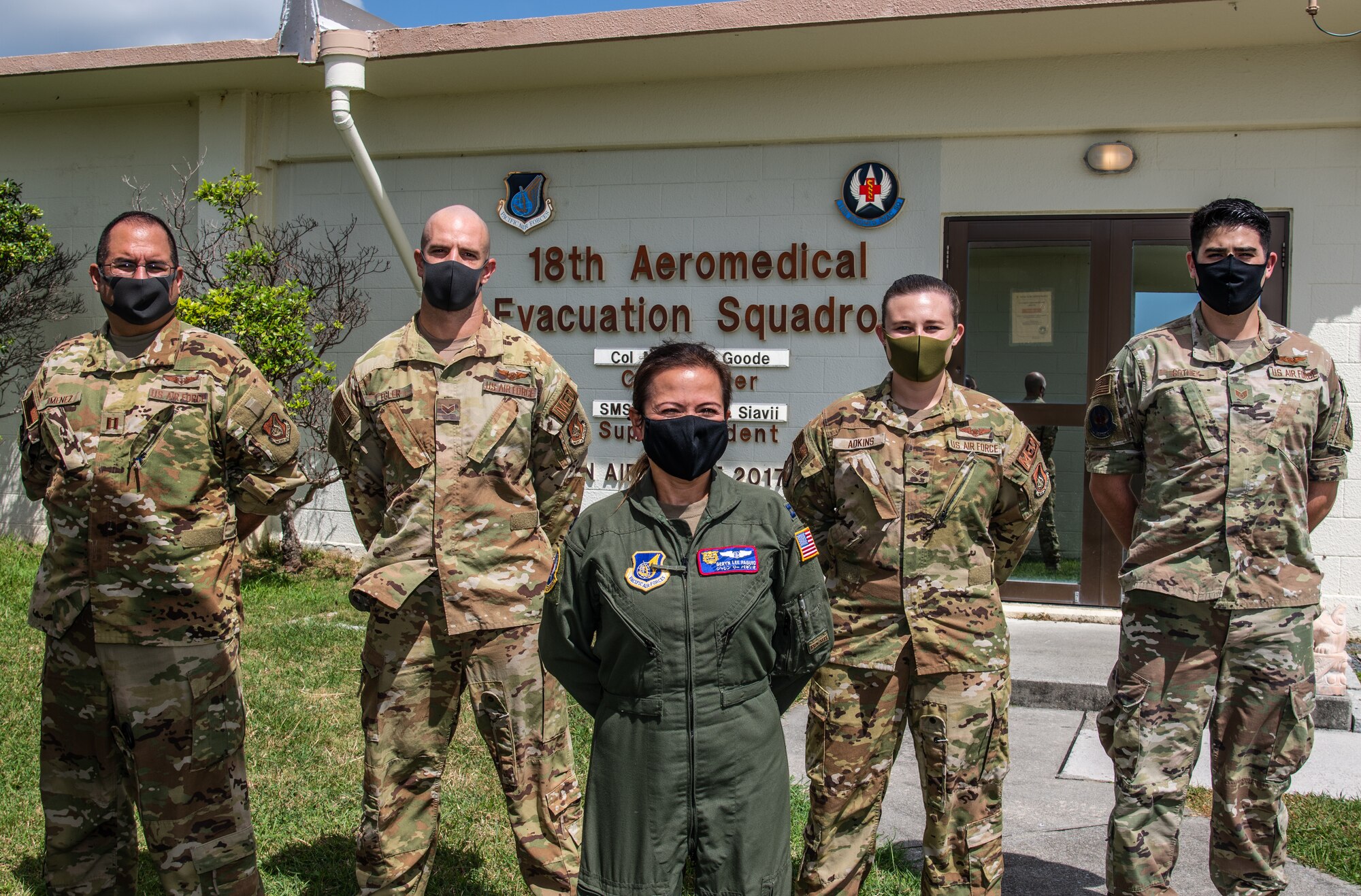 Five U.S. Air Force service members pose for a photo.