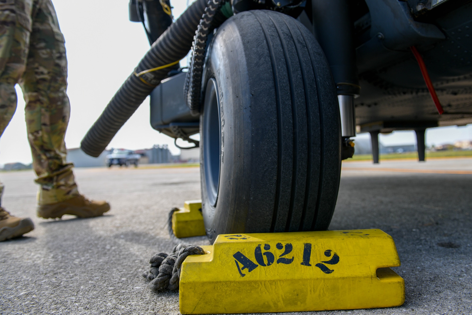 A U.S. Air Force Airman assigned to the 56th Rescue Squadron prepare an HH-60G Pave Hawk A6212 for its final sortie at Aviano Air Base, Italy, Sept. 23, 2021. Wheel chocks are wedges of sturdy material placed closely against a vehicle's wheels to prevent accidental movement and are placed for safety in addition to setting the brakes. (U.S. Air Force photo by Senior Airman Brooke Moeder)