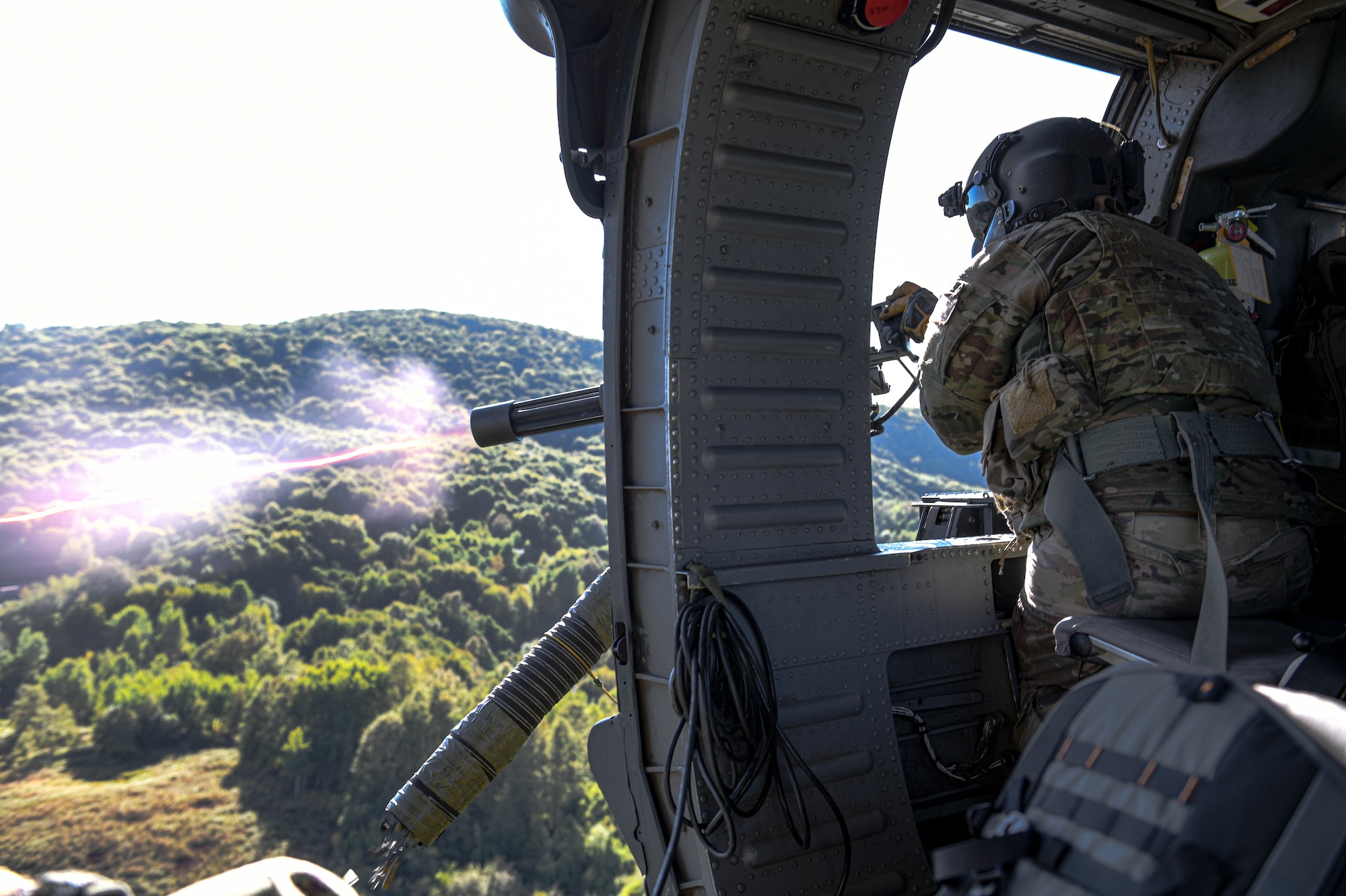 Tech. Sgt. William Mathis, 56th Rescue Squadron special missions aviator evaluator, shoots out of an HH-60G Pave Hawk during a final sortie in Croatia, Sept. 23, 2021. The 56th RQS integrated with the 173rd Army unit from Vicenza and provided top cover during a live-fire exercise. (U.S. Air Force photo by Senior Airman Brooke Moeder)
