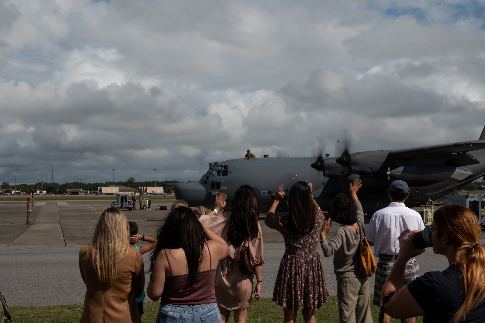 Families wave at the crew from an MC-130H Combat Talon II aircraft as they return from a deployment Oct. 6, 2021 at Hurlburt Field, Florida. The MC-130H is being phased out in time for the new MC-130J Commando II aircraft to take over the mission. (U.S. Air Force photo by Staff Sgt. Rito Smith)