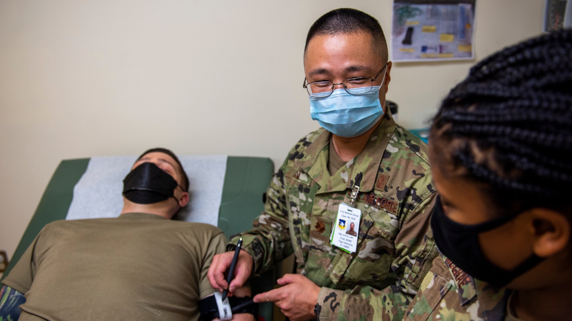 Maj. Jimmy Lam, 51st Operational Medical Readiness Squadron base operational medical clinic chief, shows a physician assistant how to apply a tourniquet