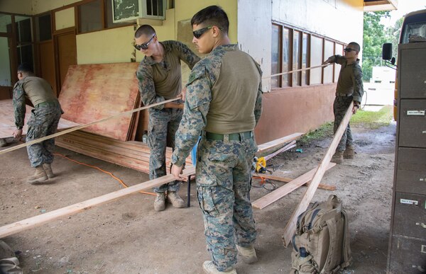 U.S. Marine Corps combat engineers with Task Force Koa Moana 21, I Marine Expeditionary Force, move wood beams to be cut at Ngeremlengui Elementary School in Ngeremlengui, Republic of Palau, Oct. 2, 2021. Task Force Koa Moana 21 provides a unique opportunity to enhance relationships with the Republic of Palau.