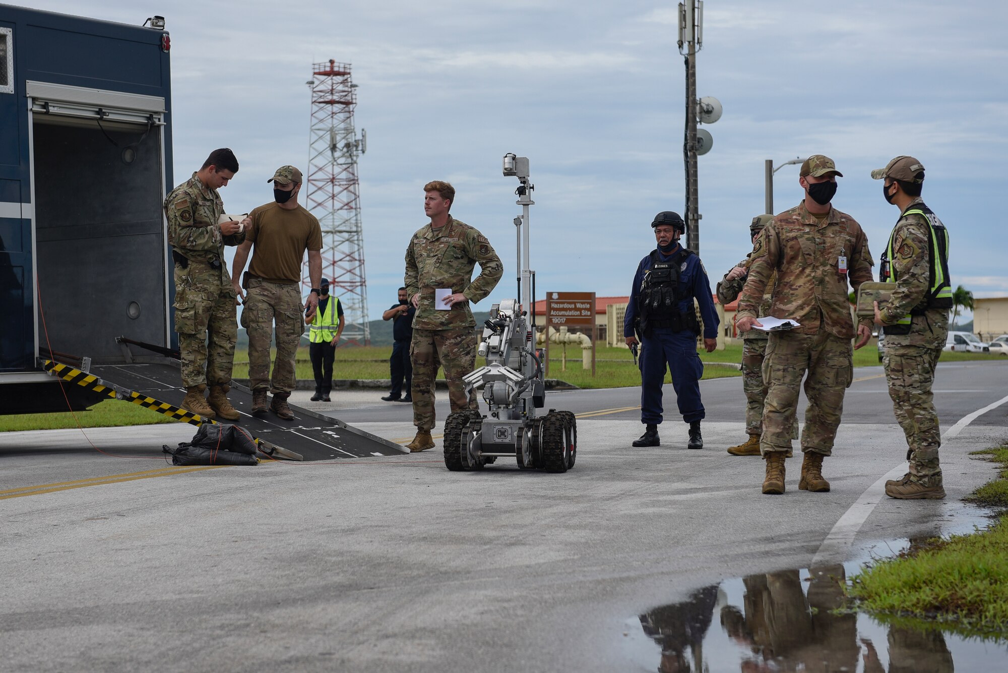 Airmen surrounding a bomb disposal robot.