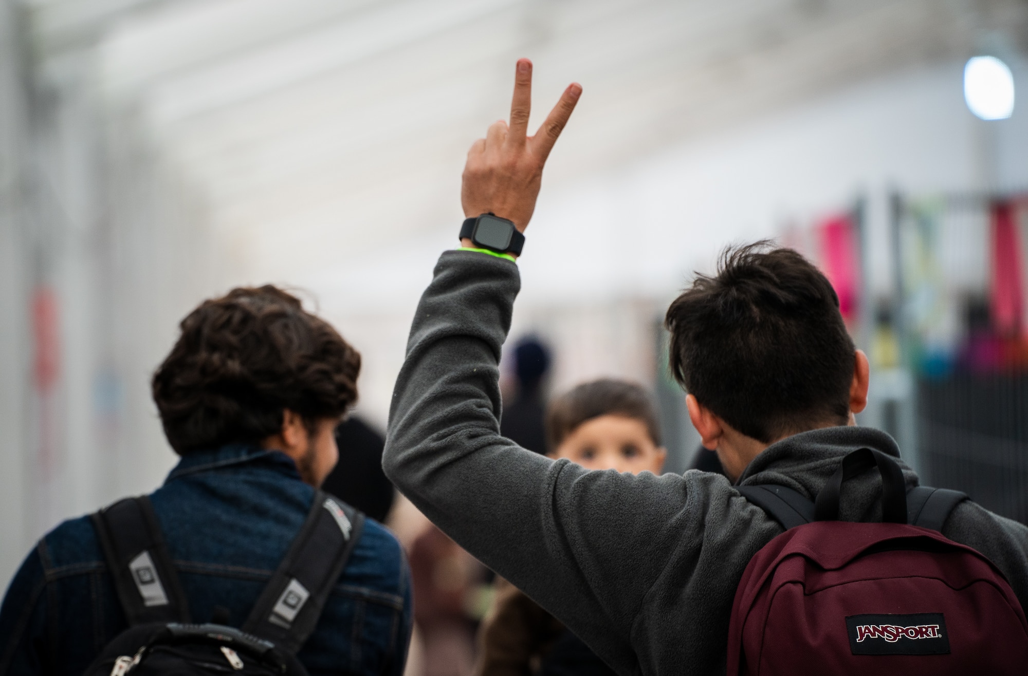 Evacuee gives peace sign while walking through passenger terminal.