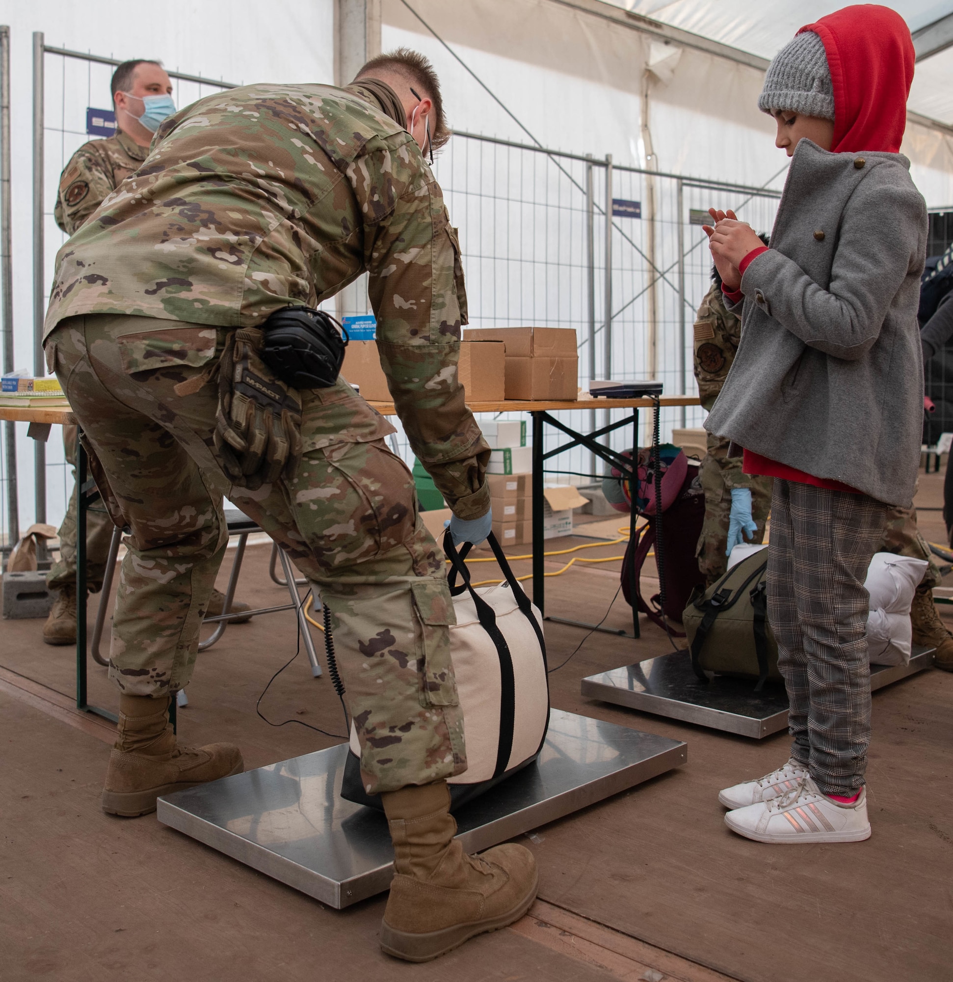 Airmen weighs evacuee luggage.
