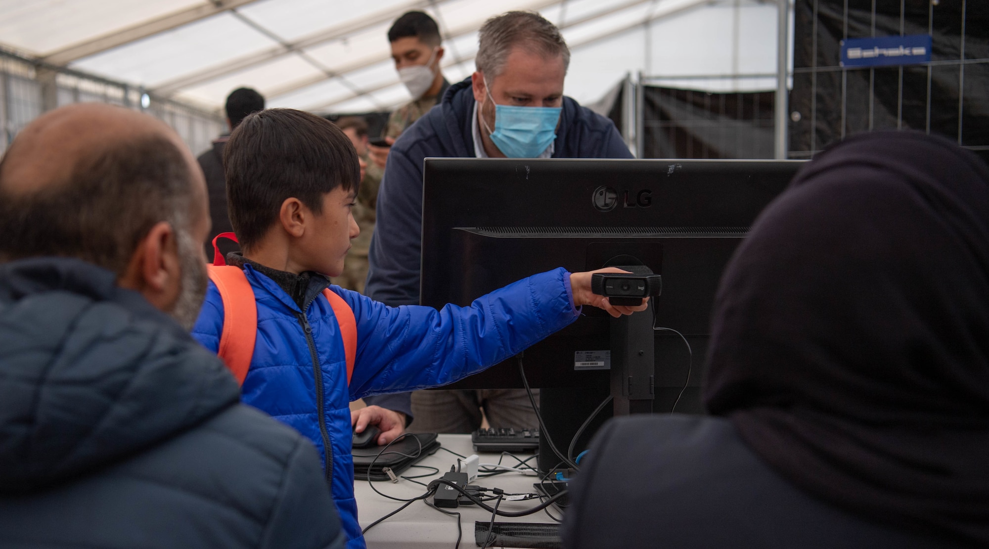 Evacuee helps takes photo of family at check point.