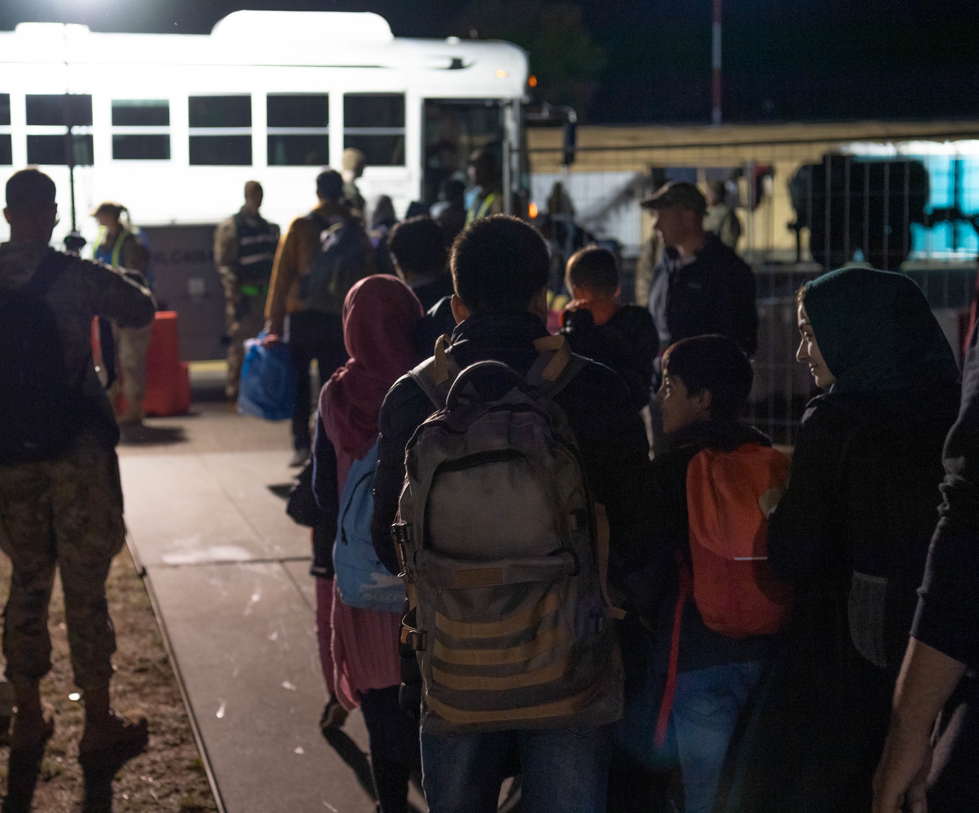 Evacuees board shuttle from passenger terminal to outbound flight.