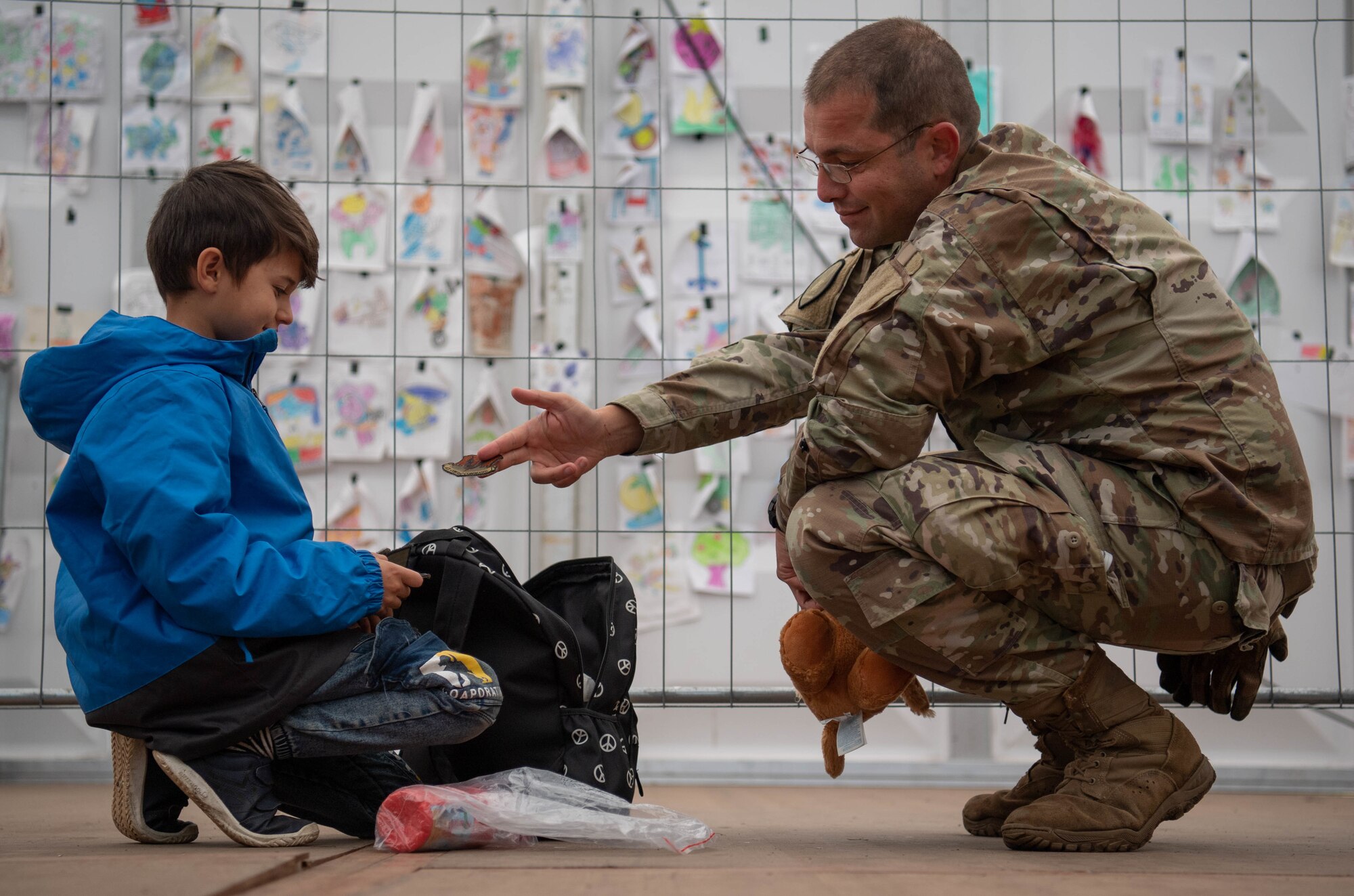 Airman hands evacuee his uniform patch.