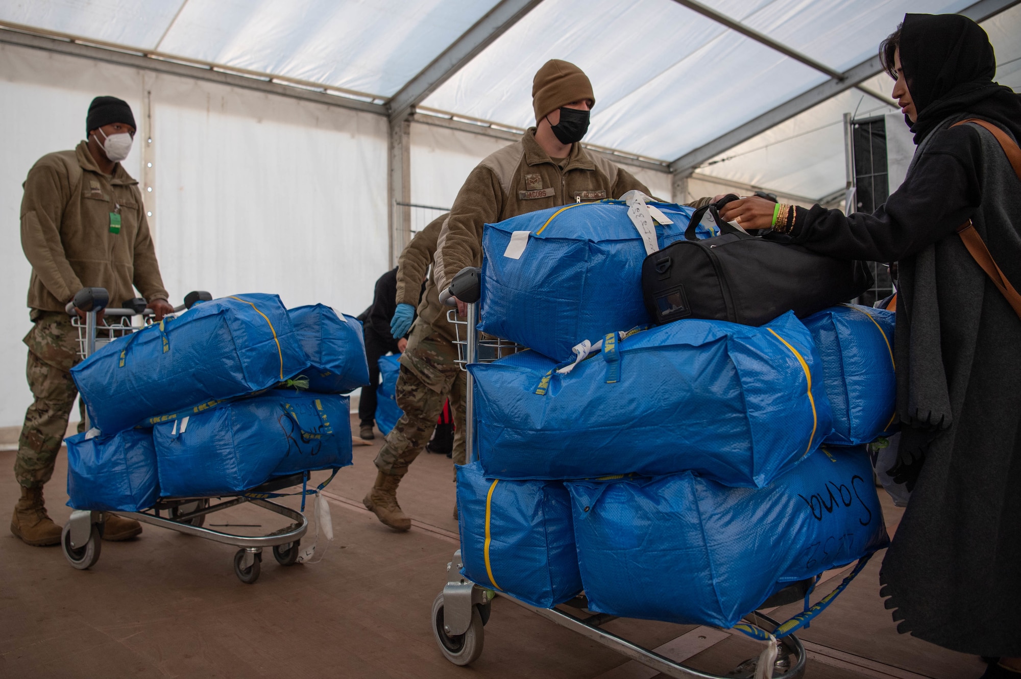 Airmen collect evacuee luggage.