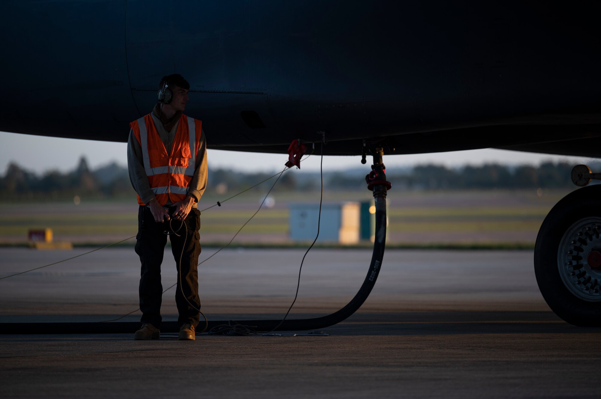 A fuels specialist assigned to the 9th Expeditionary Bomb Squadron, stands by while a B-1B Lancer is being refueled at RAF Fairford, United Kingdom, Oct 11, 2021. Fuels specialists support Bomber Task Force Europe missions by managing refueling operations necessary to support a variety of training exercises. (U.S. Air Force photo by Airman 1st Class Josiah Brown)