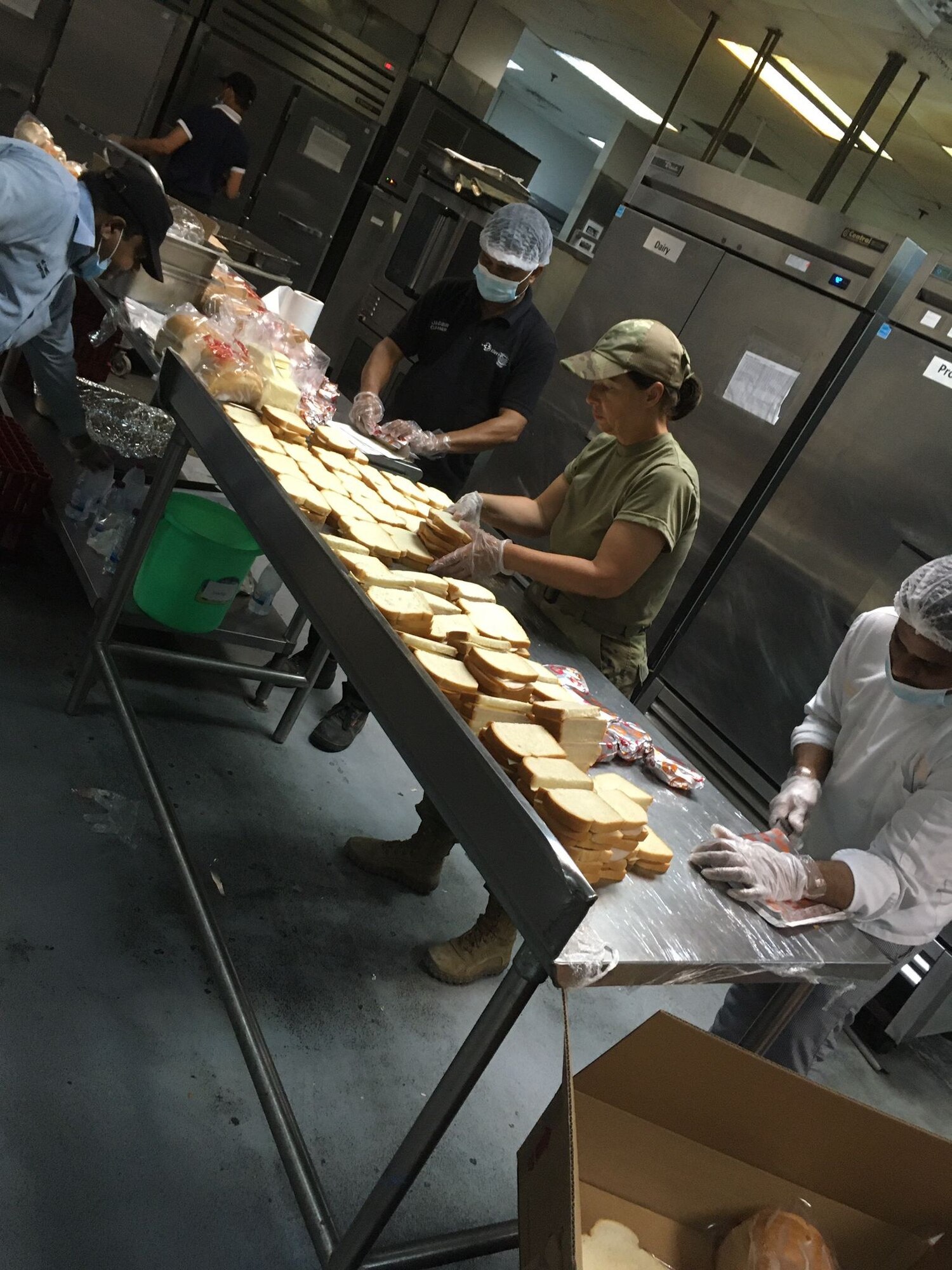 Airmen from the 379th Expeditionary Force Support Squadron and contractors make sandwiches for Afghanistan evacuees in a dining facility at Al Udeid Air Base, Qatar.