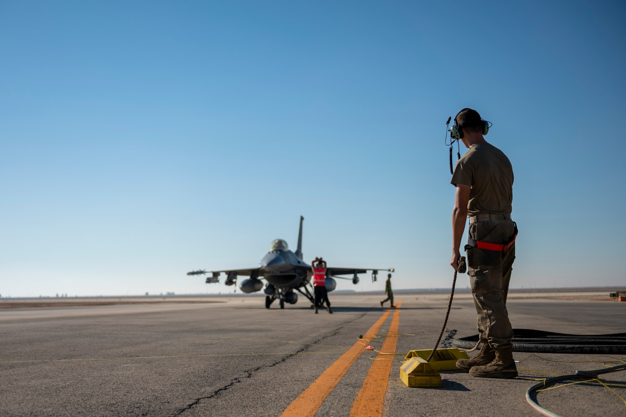 U.S. Airmen from the 332nd and 378th Air Expeditionary Wings conduct hot pit refueling of two U.S. F-16 Fighting Falcons Sept. 30, 2021, at an undisclosed location in Southwest Asia. The F-16s were forward-deployed from the 378th AEW, Prince Sultan Air Base, Kingdom of Saudi Arabia. Maintenance crews assigned to the 332nd and 378th AEWs conducted a hot-pit refueling training exchange over the course of several weeks, increasing their agile combat employment capabilities by ensuring both F-16 Fighting Falcons and F-15E Strike Eagles can be refueled by each wing. (U.S. Air Force photo by Master Sgt. Traci Keller)
