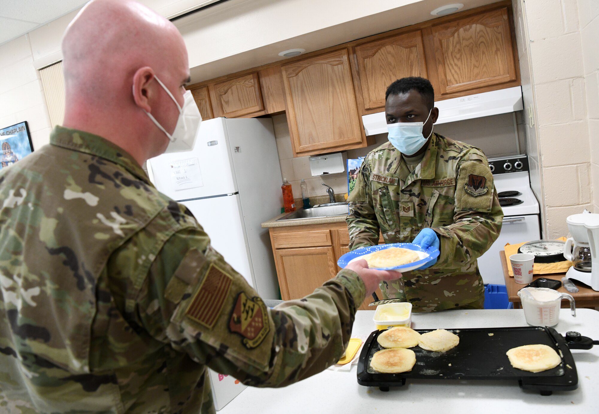 An Airmen serves another Airmen food.