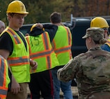 Sgt. 1st Class Courtney Weisert, NCO in charge of Team Central, Recruiting and Retention Battalion, Vermont Army National Guard, hands out free lanyards and hand sanitizer to students from Center for Technology Essex during a visit to the Camp Ethan Allen Training Site in Jericho, Vermont, on Oct. 12, 2021. Students from the Center for Technology Essex visited CEATS to gain hands-on experience with heavy equipment. (U.S. Army National Guard photo by Sgt. Dyllan Durham)