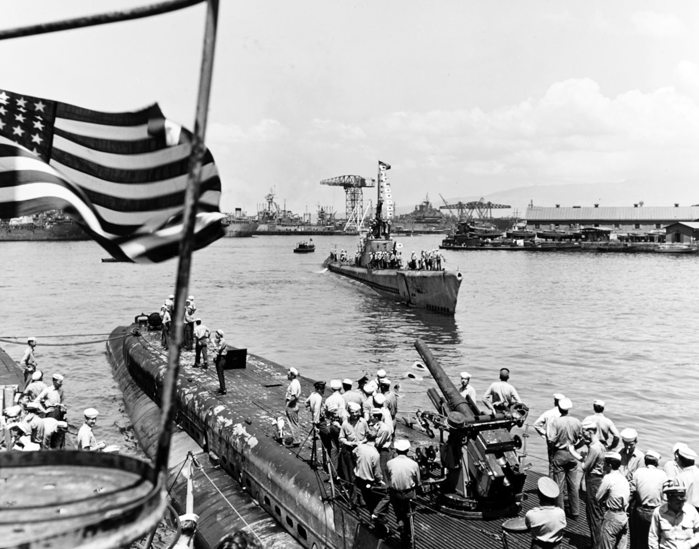 USS Tinosa (SS-283), steaming to her berth at Pearl Harbor following war patrol in Japanese home waters, flying her battleflag and several small Japanese flags representing her “kills,” ca. 1939–1945