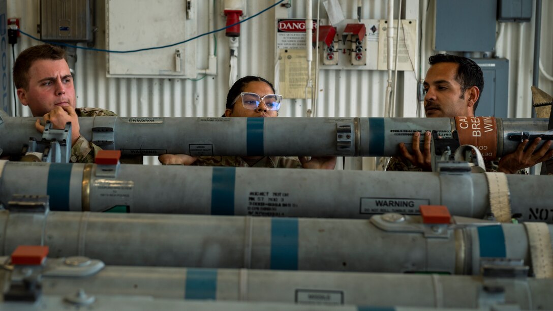Airmen lift an AIM-9 Sidewinder missile during Initial Certification training at Seymour Johnson Air Force Base, North Carolina, Oct. 12, 2021.